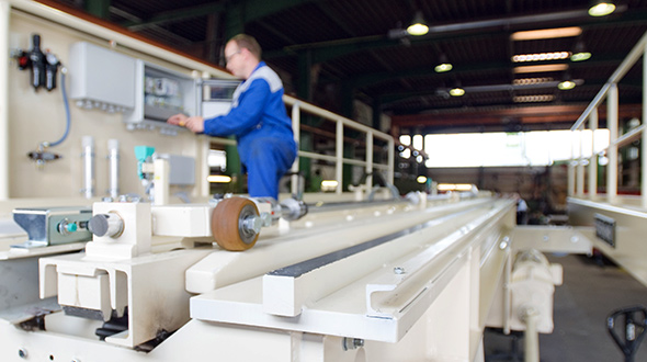 Stahlbaumeister montiert Schiebebühnen-Anlage in großer Halle für Baugruppen Montage